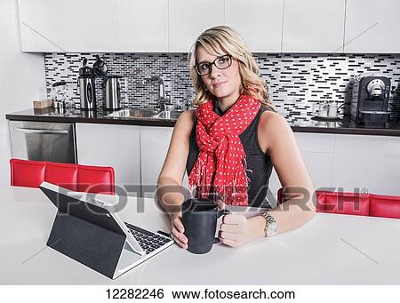 Businesswoman taking a coffee break and checking her tablet; St. Albert, Alberta, Canada View Large Photo Image Stock Photograph - Businesswoman taking a coffee break and checking her tablet; St. Albert, Alberta, Canada. Fotosearch