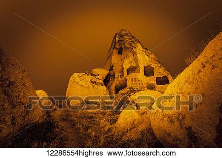 Stock Photograph - Cave homes in rock formations and fairy chimneys; Goreme, Cappadocia, Turkey. Fotosearch