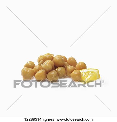 Stock Photograph - Chick peas and a piece of lemon on a white background; Toronto, Ontario, Canada. Fotosearch