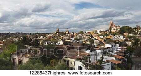 Cityscape and church in the distance under cloudy sky; San Miguel de Allende, Guanajuato, Mexico View Large Photo Image Stock Photograph - Cityscape and church in the distance under cloudy sky; San Miguel de Allende, Guanajuato, Mexico. Fotosearch