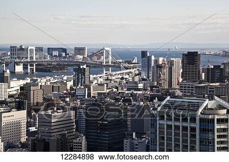 Stock Photo - Cityscape of Tokyo with a view of a bridge and ocean; Tokyo, Japan. Fotosearch