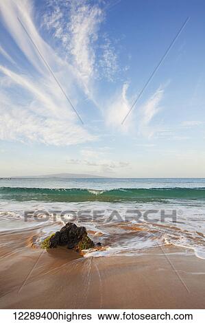 Stock Photograph - Clear blue wave at Mokapu Beach with dramatic blue sky; Wailea, Maui, Hawaii, United States of America. Fotosearch