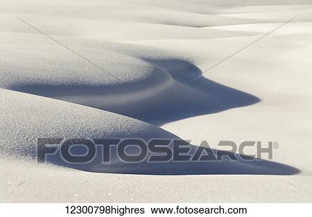 Stock Photograph - Close up detail of curvy snow shapes with shadows; Kananaskis Country, Alberta, Canada. Fotosearch