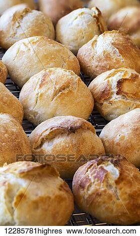Stock Photograph - Close up of round crusty buns on wire cooling rack; Calgary, Alberta, Canada. Fotosearch
