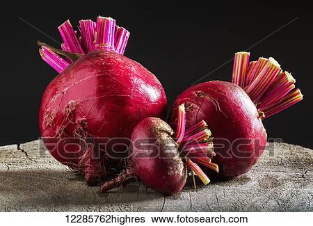 Close up of three different sized red beets on a wooden board with black background; Calgary, Alberta, Canada View Large Photo Image Stock Photograph - Close up of three different sized red beets on a wooden board with black background; Calgary, Alberta, Canada. Fotosearch
