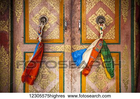 Stock Photograph - Cloth is braided together to create a decorated door pull on the doors on a Tibetan style monastery; Ladakh, India. Fotosearch