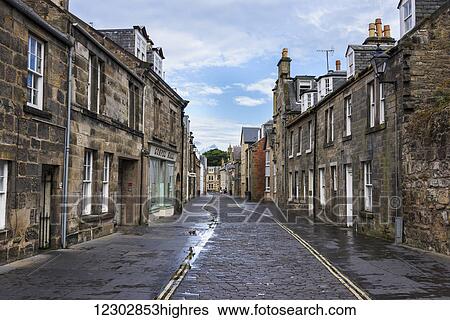 Stock Photograph - Cobblestone trail in the middle of a street running between rows of houses; St. Andrews, Fife, Scotland. Fotosearch