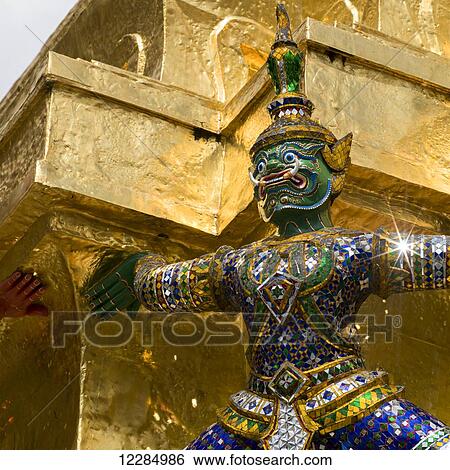 Colourful, ornate statue in from of a gold wall, Temple of the Emerald Buddha (Wat Phra Kaew); Bangkok, Thailand View Large Photo Image Stock Photograph - Colourful, ornate statue in from of a gold wall, Temple of the Emerald Buddha (Wat Phra Kaew); Bangkok, Thailand. Fotosearch