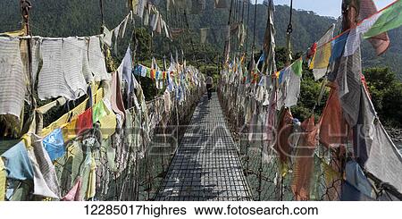 Stock Photograph - Colourful prayer flags lining a walkway; Thimphu, Bhutan. Fotosearch