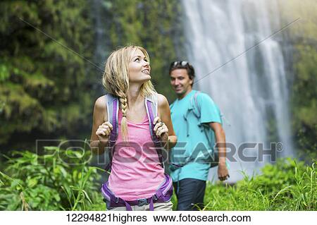 Couple having fun together outdoors on hike to amazing waterfall in Hawaii. View Large Photo Image Stock Photograph - Couple having fun together outdoors on hike to amazing waterfall in Hawaii.. Fotosearch