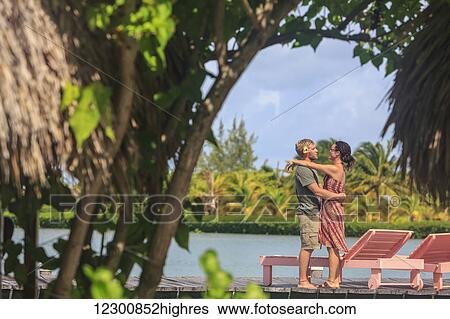 Couple on a wooden dock in an embrace, Saint Georges Caye Resort; Belize City, Belize View Large Photo Image Stock Photograph - Couple on a wooden dock in an embrace, Saint Georges Caye Resort; Belize City, Belize. Fotosearch
