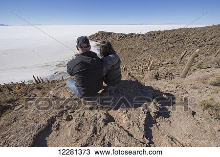 Couple sitting on an island of rock and cactus called Incahuasi; Uyuni, Bolivia View Large Photo Image Stock Image - Couple sitting on an island of rock and cactus called Incahuasi; Uyuni, Bolivia. Fotosearch