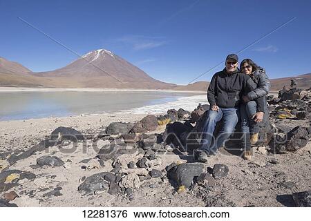 Couple sitting on the shores of Laguna Verde, a salt lake on the Chilean border; Bolivia View Large Photo Image Stock Photograph - Couple sitting on the shores of Laguna Verde, a salt lake on the Chilean border; Bolivia. Fotosearch