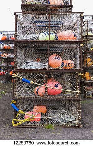 Stock Image - Crab pots and bouys stacked on shore, St. Paul Harbor, St. Paul Island, Southwestern Alaska, USA. Fotosearch