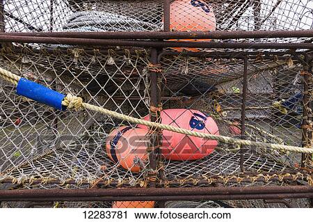 Stock Image - Crab pots and bouys stacked on shore, St. Paul Harbor, St. Paul Island, Southwestern Alaska, USA. Fotosearch