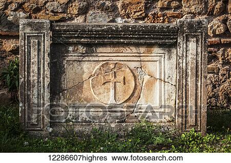 Stock Photograph - Cracked stone structure with a cross; Delphi, Greece. Fotosearch