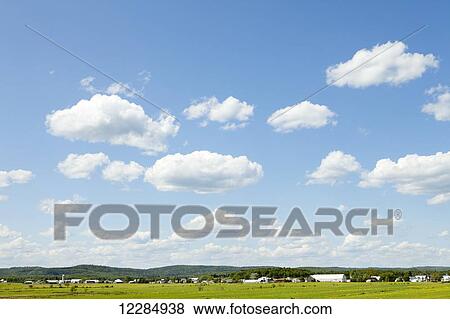 Stock Photo - Cultivated field, farm in background; Quebec, Canada. Fotosearch
