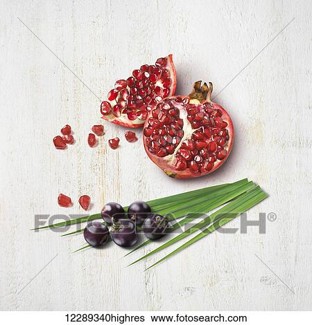 Cut pomegranate with seeds, leaf and berries; Toronto, Ontario, Canada View Large Photo Image Stock Photograph - Cut pomegranate with seeds, leaf and berries; Toronto, Ontario, Canada. Fotosearch