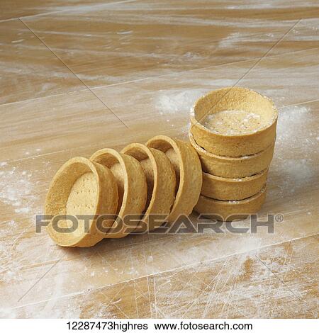 Stock Photograph - Dessert cups in a pile on a floured surface; Toronto, Ontario, Canada. Fotosearch