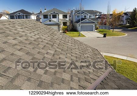 Detail of brand new roof shingles with neighbourhood houses, autumn colours and blue sky in the background; Calgary, Alberta, Canada View Large Photo Image Stock Photograph - Detail of brand new roof shingles with neighbourhood houses, autumn colours and blue sky in the background; Calgary, Alberta, Canada. Fotosearch