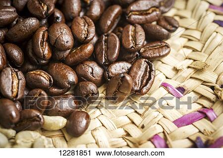 Stock Image - Detail of roasted Ethiopian coffee beans on woven straw plate; Takoma Park, Maryland, United States of America. Fotosearch
