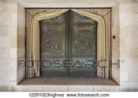 Stock Photograph - Double doors with green facade and curtains pulled back on a church building; Tabgha, Israel. Fotosearch