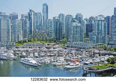 Stock Image - Downtown waterfront with boats in Coal Harbour Marina, a popular Vancouver moorage location, and the skyline; Vancouver, British Columbia, Canada. Fotosearch