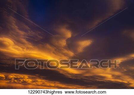 Dramatic colourful clouds at sunset with interesting formations and some blue sky; Calgary, Alberta, Canada View Large Photo Image Stock Photograph - Dramatic colourful clouds at sunset with interesting formations and some blue sky; Calgary, Alberta, Canada. Fotosearch