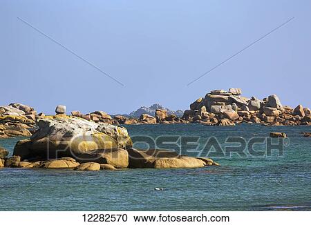 Stock Image - Dramatic rock formations in a bay with blue sky; Ploumanach, Perros-Guirec, Brittany, France. Fotosearch