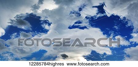 Stock Photograph - Dramatic storm clouds with blue sky in openings; Calgary, Alberta, Canada. Fotosearch