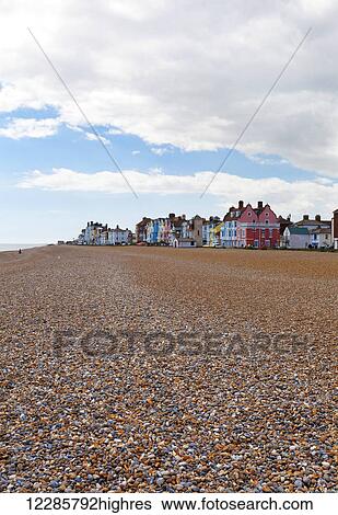 Empty beach with colourful resort houses in the distance; Aldeburgh, Suffolk, England View Large Photo Image Stock Photograph - Empty beach with colourful resort houses in the distance; Aldeburgh, Suffolk, England. Fotosearch