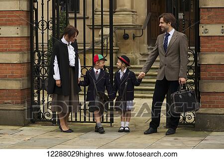 Stock Photograph - Family of four at an old school gate; London, England. Fotosearch