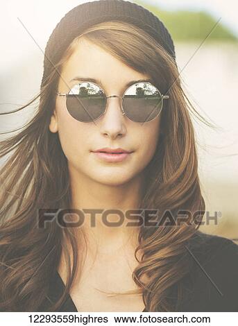 Stock Photograph - Fashion Portrait of Beautiful Stylish Young Woman in Hat and Sunglasses. Fotosearch