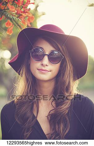 Stock Photograph - Fashion Portrait of Beautiful Stylish Young Woman in Hat and Sunglasses. Fotosearch