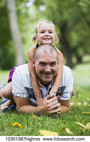 Stock Photograph - Father and daughter spending quality time together in a park; Edmonton, Alberta, Canada. Fotosearch
