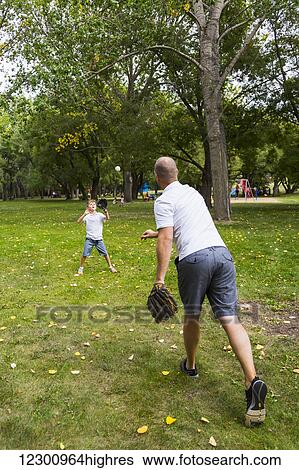 Father and son playing baseball in a park; Edmonton, Alberta, Canada View Large Photo Image Stock Photograph - Father and son playing baseball in a park; Edmonton, Alberta, Canada. Fotosearch