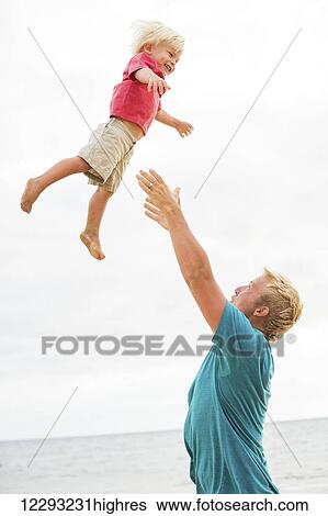 Father and son playing on the beach View Large Photo Image Stock Photograph - Father and son playing on the beach. Fotosearch
