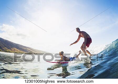 Stock Photograph - Father and Son Surfing Together Riding Blue Ocean Wave. Fotosearch
