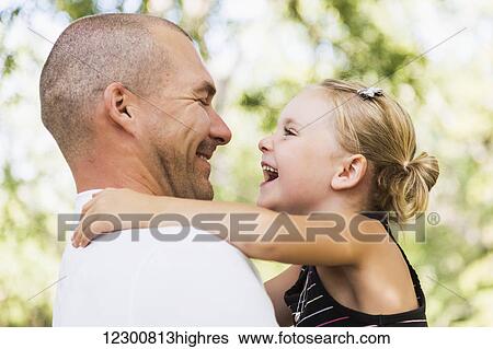 Father holding his daughter in a park in autumn; Edmonton, Alberta, Canada View Large Photo Image Stock Photograph - Father holding his daughter in a park in autumn; Edmonton, Alberta, Canada. Fotosearch