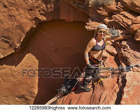 Stock Photograph - Female adventurer exploring a desert slot canyon, San Rafael Swell; Utah, United States of America. Fotosearch