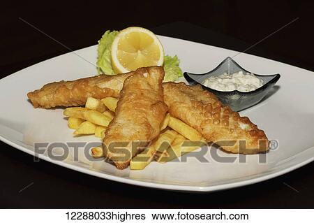 Stock Photograph - Fish and chips with lemon and sauce; Ankara, Turkey. Fotosearch