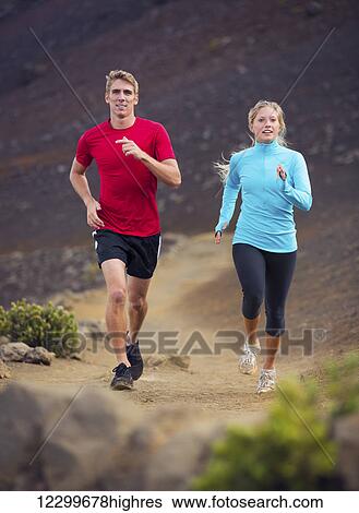 Stock Photograph - Fitness sport couple running jogging outside on trail. Fotosearch