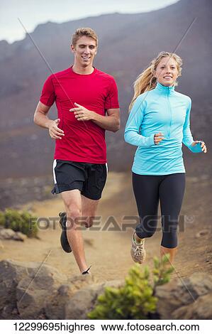 Stock Photograph - Fitness sport couple running jogging outside on trail. Fotosearch