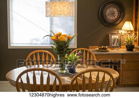 Stock Photograph - Flowers on a table lit by the afternoon sun; Chilliwack, British Columbia, Canada. Fotosearch