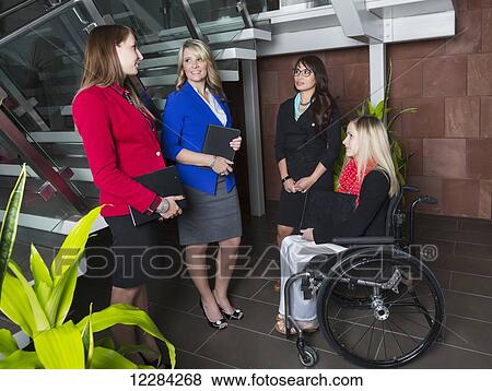 Four professional business women in the lobby of an office, one of which is a paraplegic in a wheelchair; St. Albert, Alberta, Canada View Large Photo Image Stock Photo - Four professional business women in the lobby of an office, one of which is a paraplegic in a wheelchair; St. Albert, Alberta, Canada. Fotosearch