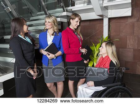 Four professional business women in the lobby of an office, one of which is a paraplegic in a wheelchair; St. Albert, Alberta, Canada View Large Photo Image Stock Photo - Four professional business women in the lobby of an office, one of which is a paraplegic in a wheelchair; St. Albert, Alberta, Canada. Fotosearch