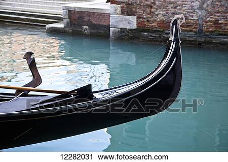 Stock Image - Front of a gondola in a canal with turquoise water; Venice, Italy. Fotosearch