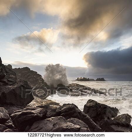 Glowing clouds at sunset with waves crashing against the rocks; Tofino, British Columbia, Canada View Large Photo Image Stock Photograph - Glowing clouds at sunset with waves crashing against the rocks; Tofino, British Columbia, Canada. Fotosearch