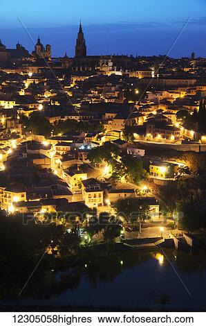 Stock Photograph - Golden lights illuminate a historic city; Toledo, Castile-La Mancha, Spain. Fotosearch