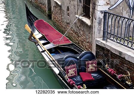 Stock Photography - Gondola moored along a building in a canal; Venice, Italy. Fotosearch
